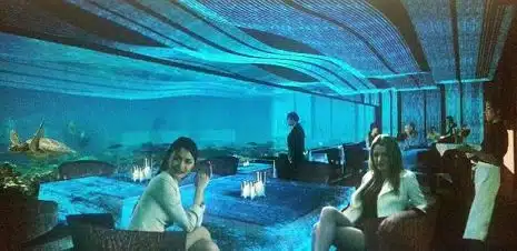 An imaginative concept of an underwater restaurant at Sipadan island, with diners watching sharks and fish swim by as they eat.