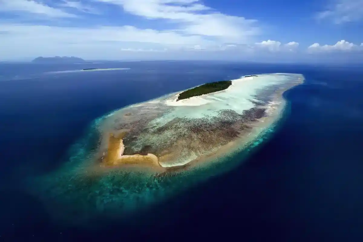 Beautiful aerial view of Mataking Island connected to the smaller Mataking Kecil by a pristine white sandbar at low tide.
