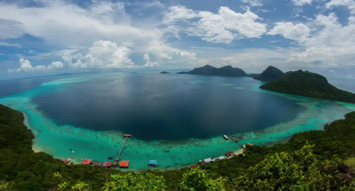 Iconic panoramic vista from the Bohey Dulang viewpoint, showcasing the stunning volcanic island and turquoise reefs of the Tun Sakaran Marine Park islands and lagoons.
